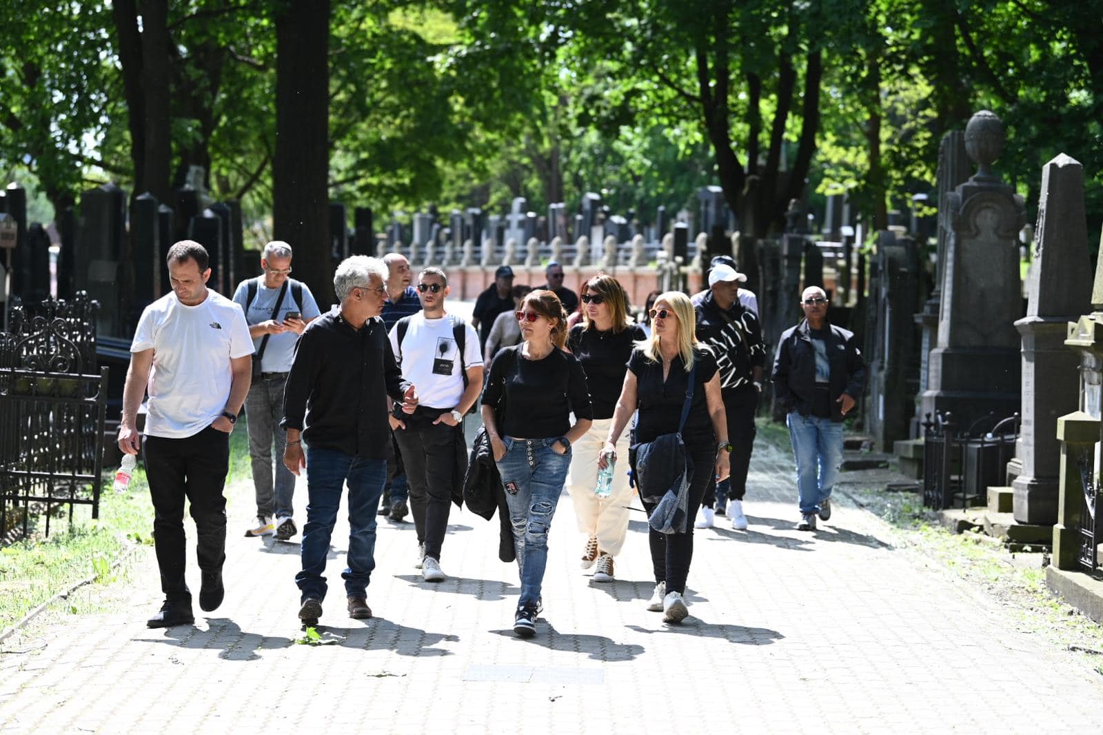 קבוצת משתתפים מסיירת בשביל של בית עלמין יהודי בפולין
