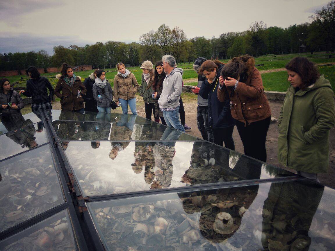 סטודנטים מתבוננים בתצוגה מזוגגת של נעליים שהושארו במחנה ההשמדה מיידנק
