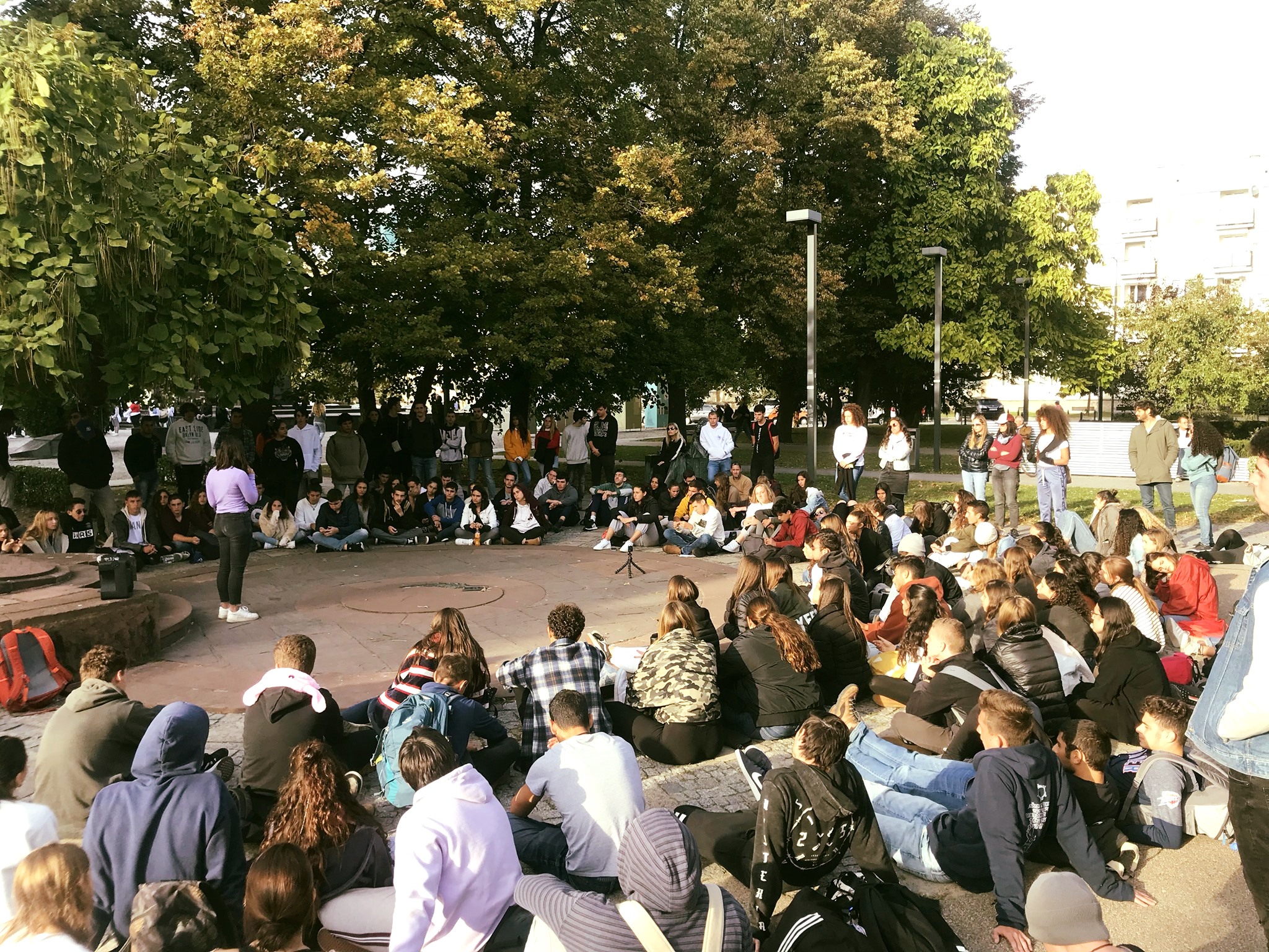 משתתפי מסע בני נוער יושבים במעגל דיון בכיכר בפולין